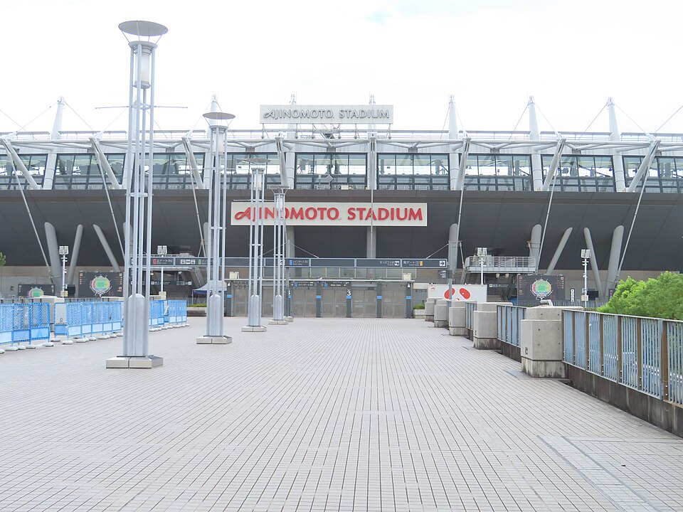 味の素スタジアムの名称看板と正面ゲート、入口前の広い歩行者デッキが見える外観