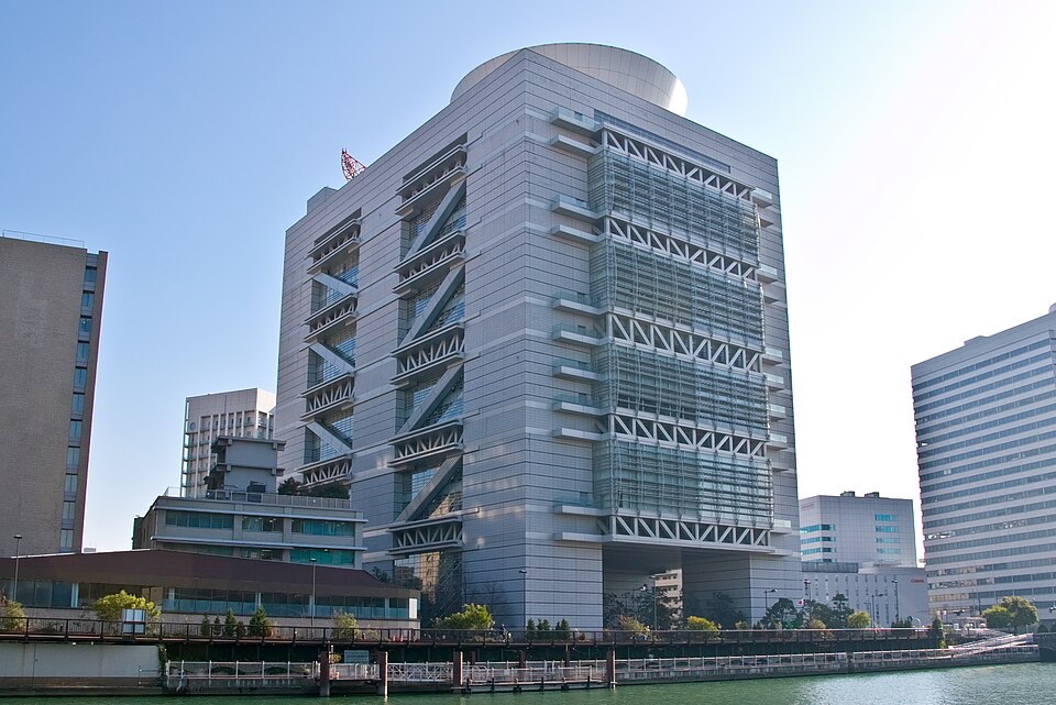 川沿いから見たグランキューブ大阪のガラス面と外付け階段がある高層建物
