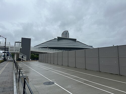 広島グリーンアリーナの屋根を奥に望む歩道と仮囲いのある周辺