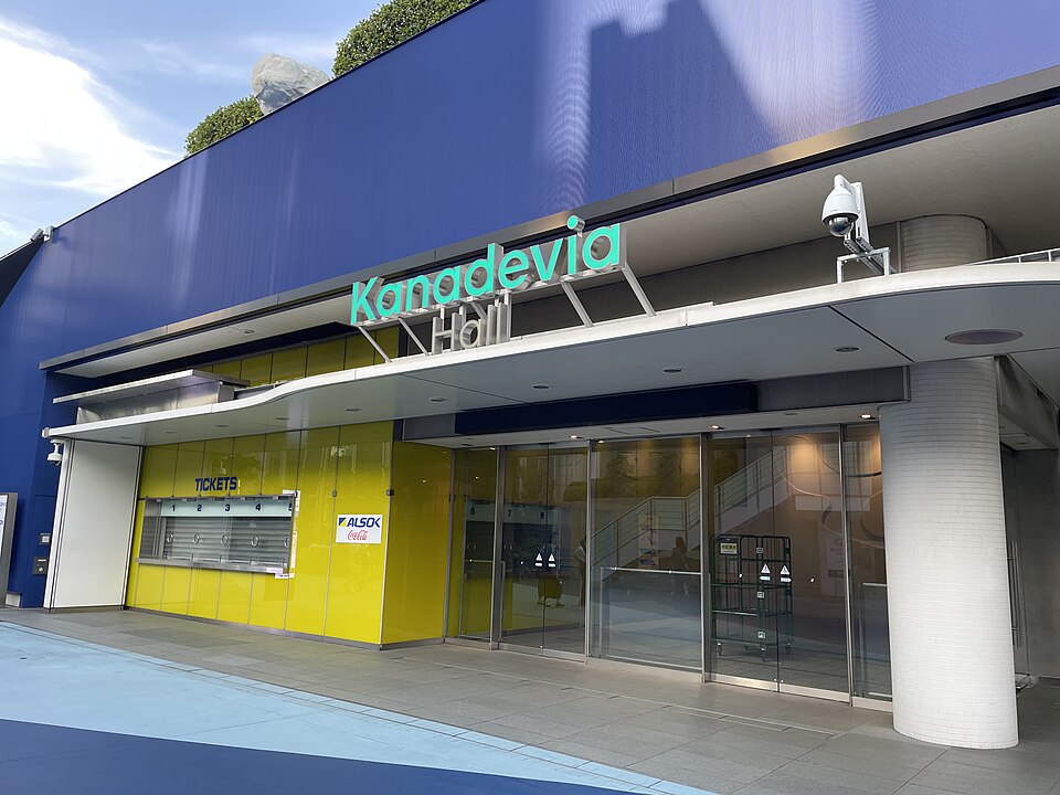 Kanadevia Hallの現名称の看板、ガラス扉と黄色いチケット窓口のある入口