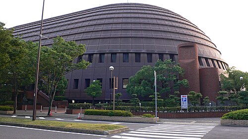 道路と横断歩道の奥に見えるワールド記念ホールの丸い屋根と周辺の木々