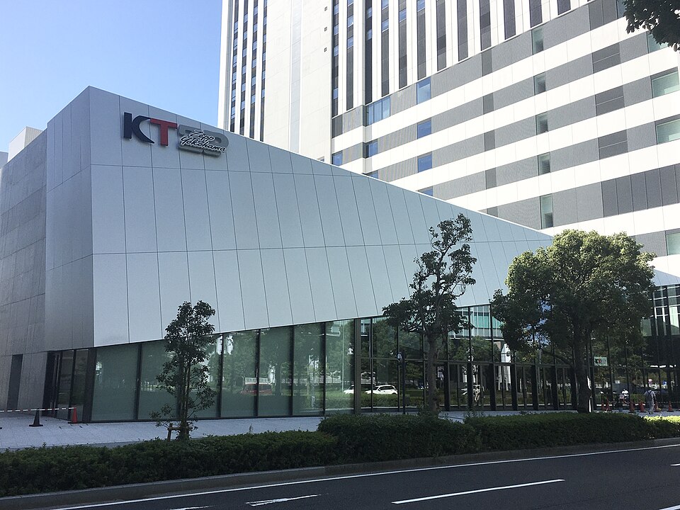 白い外壁上部にKT Zepp Yokohamaの看板があり、ガラス張りの入口側と道路が見える昼の外観