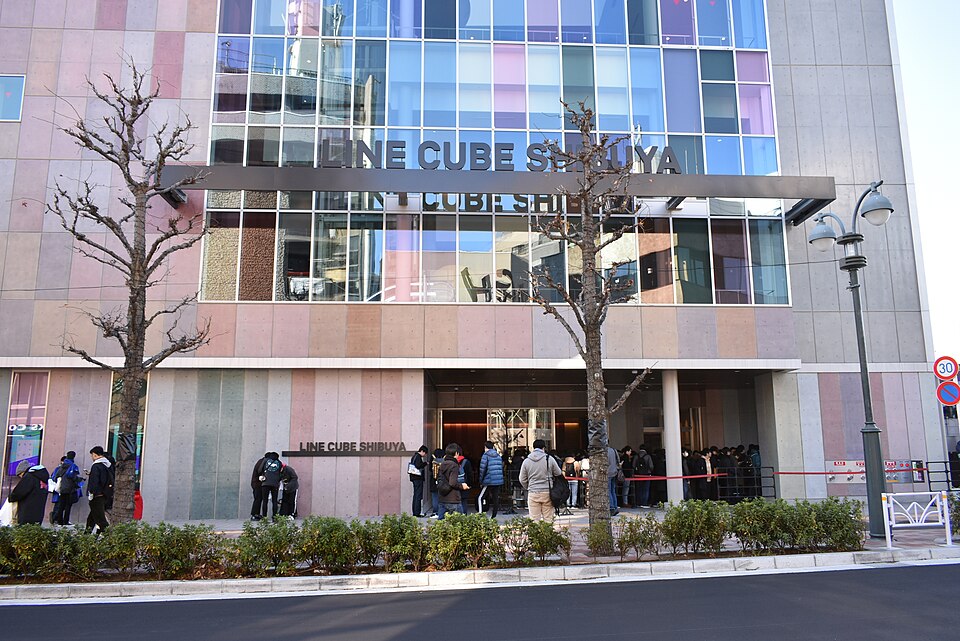 青空の下、ガラスの正面にLINE CUBE SHIBUYAの看板と入口が見える新館の外観