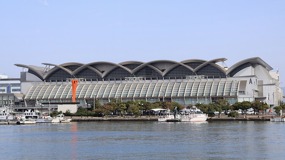 水面の向こうに波形の屋根とAの表記が見えるマリンメッセ福岡A館