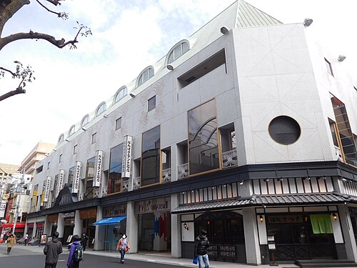 街路樹の横から建物の角と入口前の通りを見たなんばグランド花月