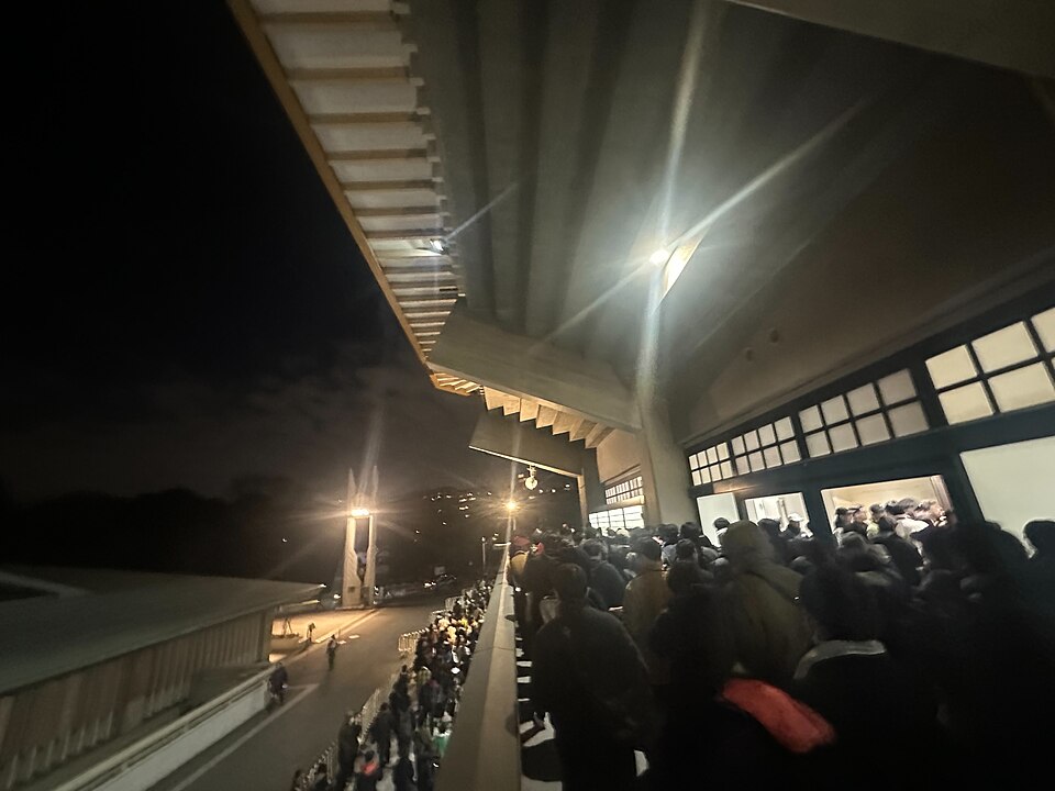 夜の日本武道館の建物沿いの通路と人の流れ