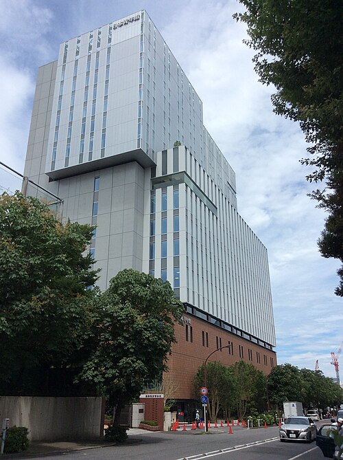 日本青年館の文字を上部に掲げた現建物全景と手前の通りや街路樹