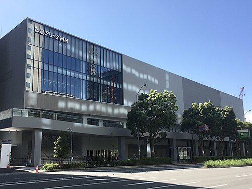 会場名の看板とガラス壁、街路樹が見えるぴあアリーナMMの道路側外観