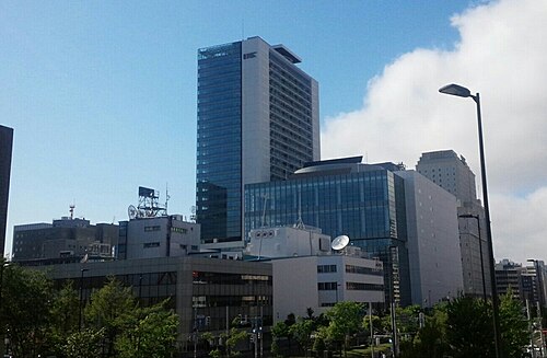 遠方から見たさっぽろ創世スクエアの高層部と低層部、手前の建物や木々が続く街並み