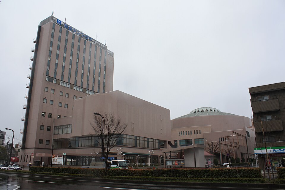 高いホテル棟と右側の丸い屋根のホールが並ぶ仙台サンプラザの道路側外観