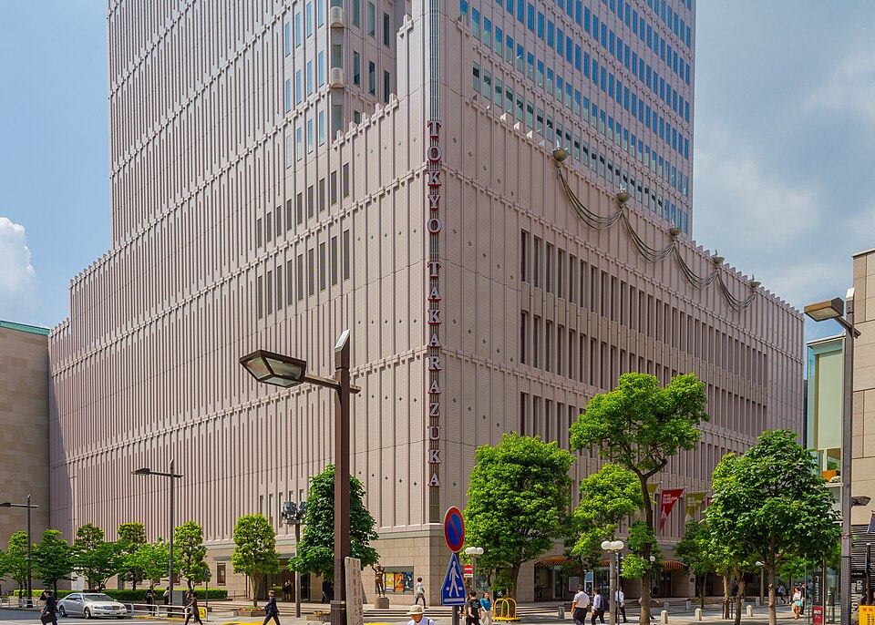 街路樹の向こうにTOKYO TAKARAZUKAの縦看板が見える東京宝塚劇場の建物外観