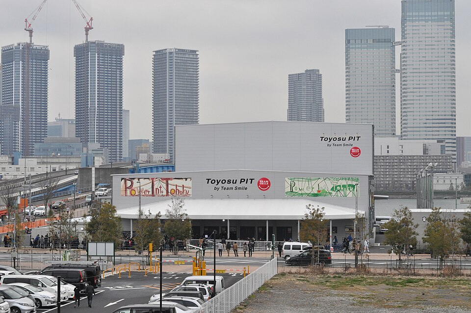 豊洲PITの建物全体と周辺の道路や高層ビルが見える昼間の外観
