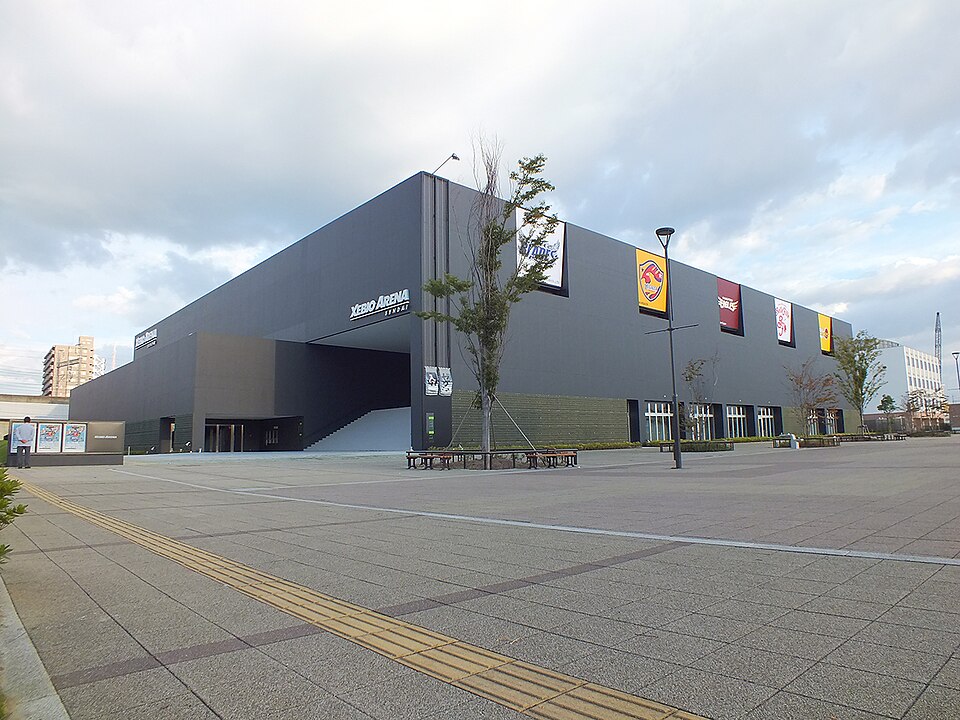 入口前の広場から見た黒い外壁のゼビオアリーナ仙台と建物の看板