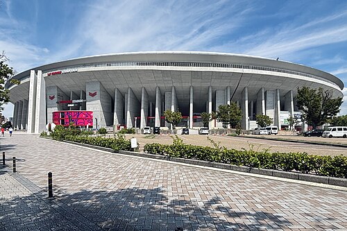 ヤンマースタジアム長居の全体外観と、前に広がる歩道や植え込み