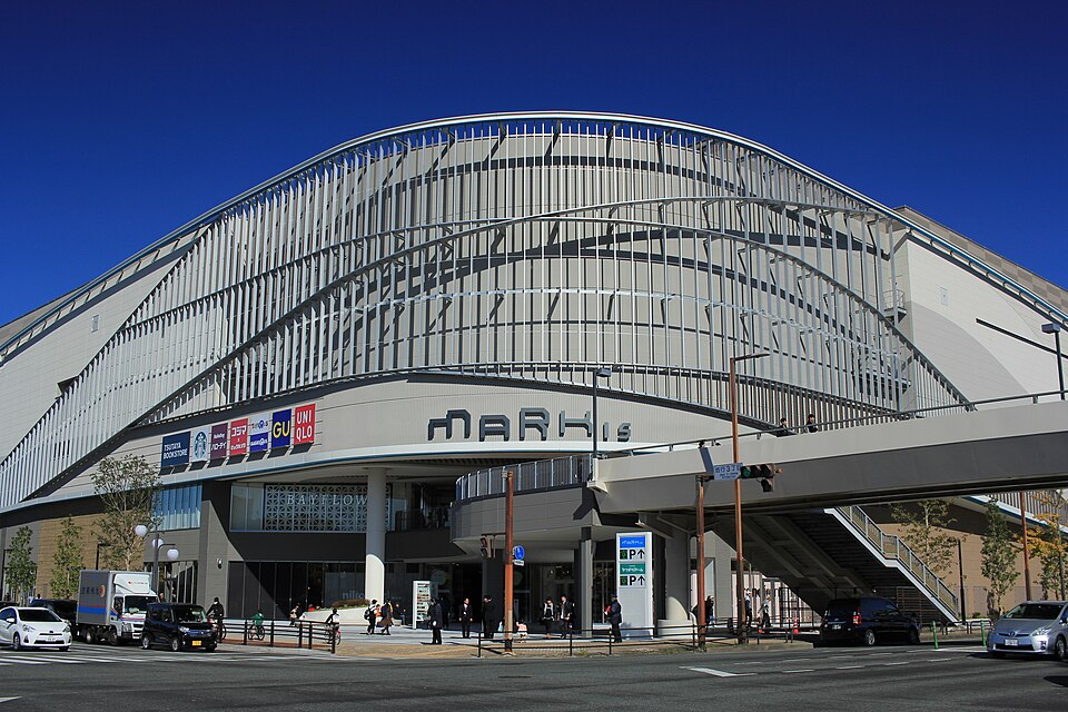 MARK IS 福岡ももちの白い曲線状の外壁と看板、前の道路と歩道橋