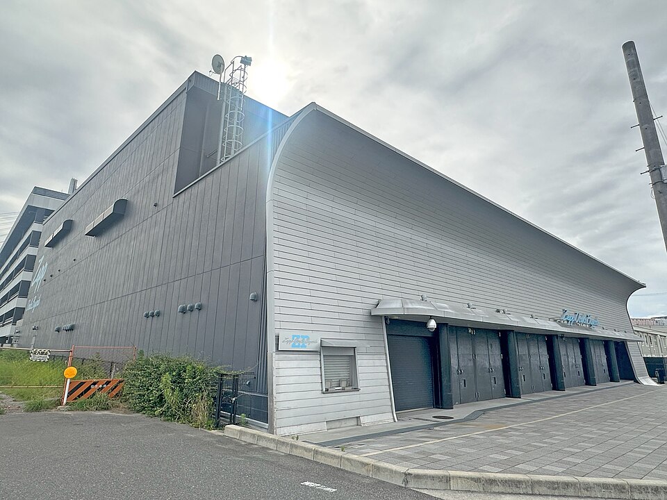 Zepp Osaka Baysideの扉が並ぶ正面と側面、前の舗装されたスペース